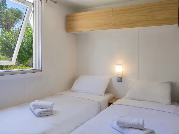 Une chambre avec des lits simples dans le mobil-home Roan Supreme avec 2 salles de bain.