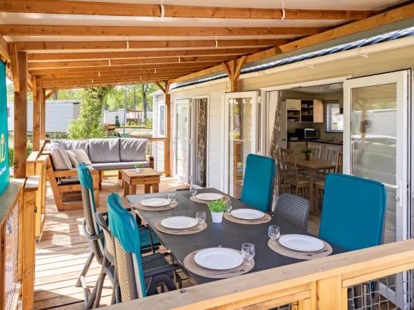 La terrasse spacieuse du Comfort Lounge est meublée d'une table, de chaises et d'un canapé confortable.