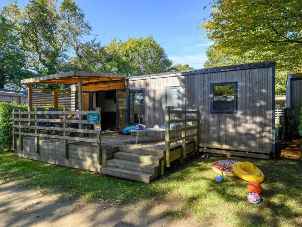 La véranda du Roan Premium est équipée d'une table à manger et de chaises de jardin.