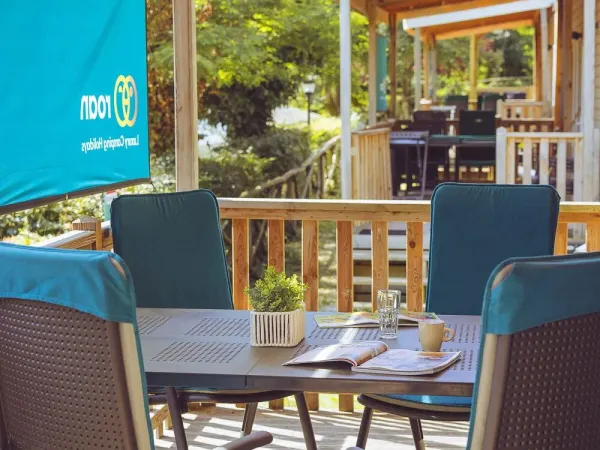 La véranda du Roan Premium Compact est équipée d'une table à manger et de chaises.