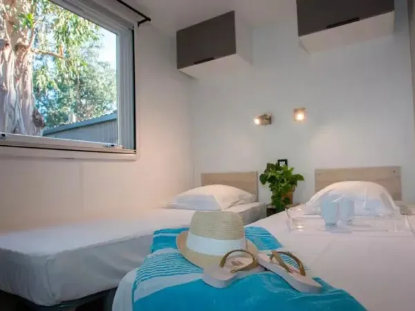Une chambre avec des lits simples dans le mobil-home Roan Supreme avec 2 salles de bain.