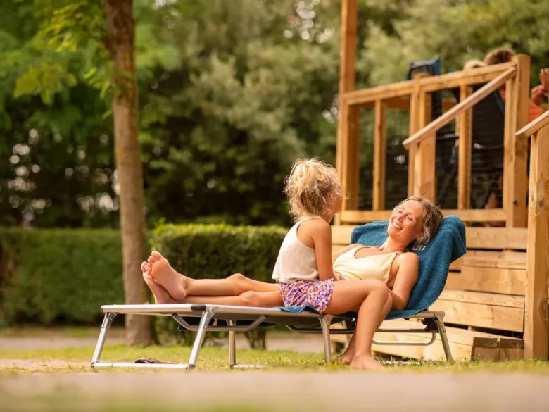 Mère et fille sur la luxueuse chaise longue à baldaquin.
