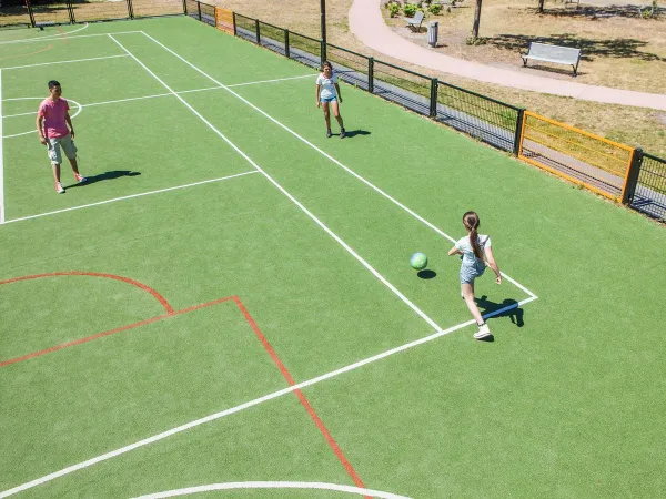 Jouer au football sur le terrain de sport du camping Roan De Schatberg.