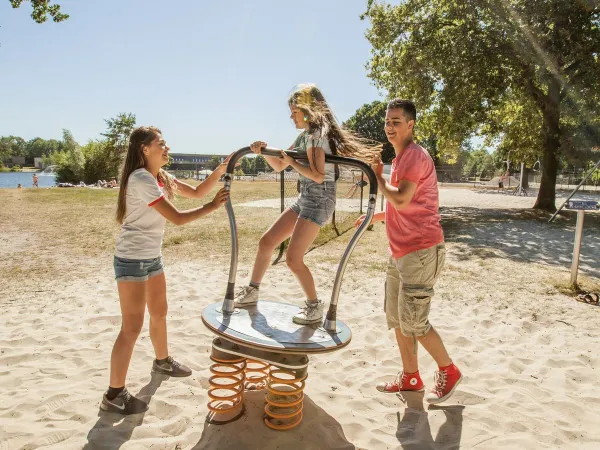 Les enfants jouent dans l'aire de jeux du camping Roan De Schatberg.