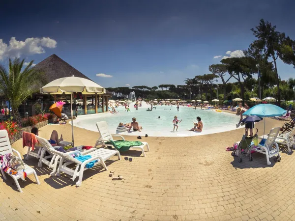 Chaises longues au bord de la piscine pour les tout-petits du camping Roan Albatros.