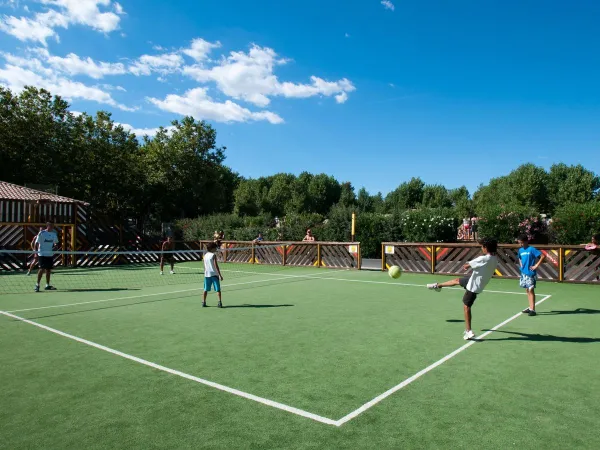 Jouer au football sur le terrain multisports du camping Roan Domaine de La Yole.