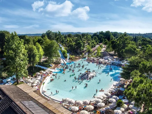 Vue d'ensemble de la piscine lagon avec toboggans au camping Roan hu Altomincio village.