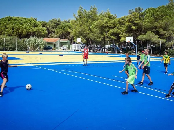 Jouer au football sur le terrain multisports du camping Roan Zaton Holiday resort.