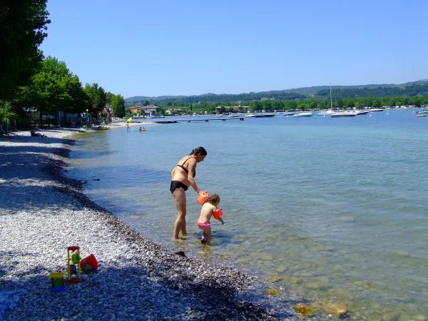 Mère avec bébé dans le lac au Roan camping La Rocca Manerba.