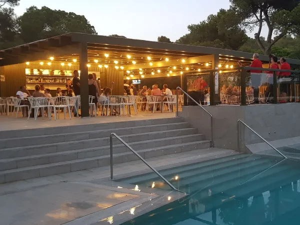 Terrasse au bord de la piscine le soir au camping Roan Cala Gogo.