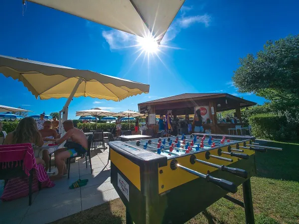 Baby-foot et terrasse au camping Roan Rubicone.