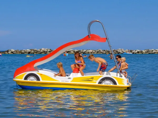 Pédalo avec toboggan dans la mer au camping Roan Rubicone.