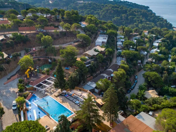 Camping Roan Cala Canyelles : aperçu de la piscine et de l'hébergement.