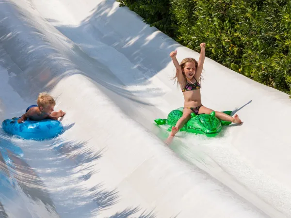 Glisser sur les toboggans avec des structures gonflables au camping Roan hu Altomincio village.