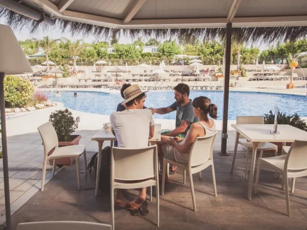 Terrasse à côté de la piscine du camping Roan Tucan.