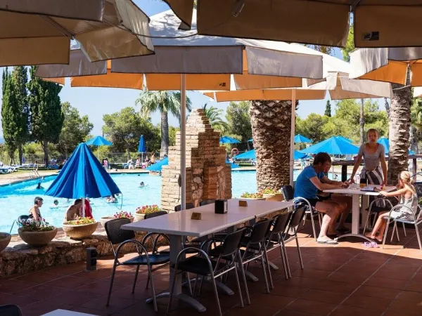 Terrasse au bord de la piscine du camping Roan Vilanova Park.