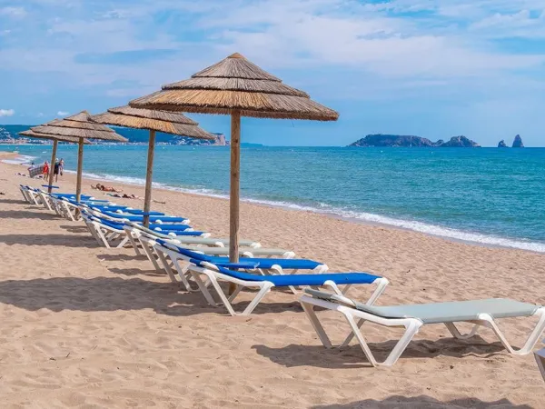 Chaises longues sur la plage du camping Roan Playa Brava.