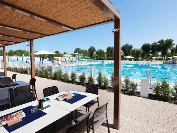 Terrasse à côté de la piscine du camping Roan Marina Di Venezia.