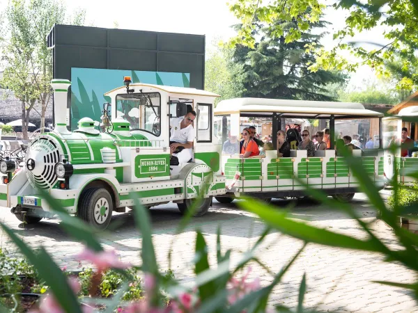 Le train du camping conduit les visiteurs à travers le camping Roan hu Altomincio village.