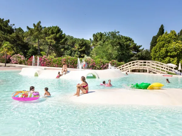 Piscine pour enfants avec surface souple et toboggans au camping Roan Norcenni Girasole.