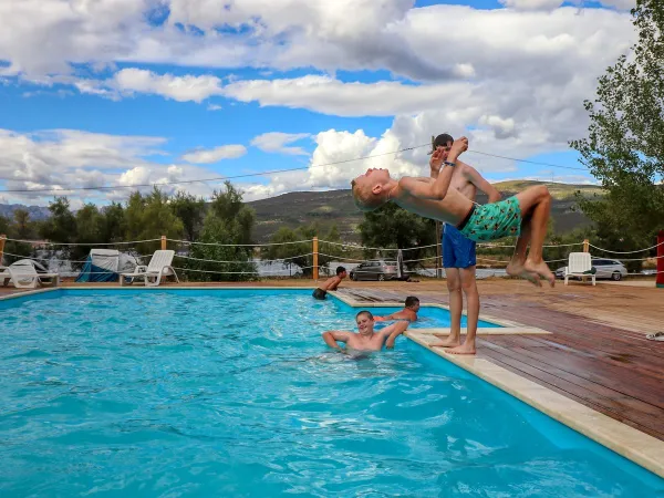 Des jeunes jouent dans la piscine du camping Roan Karin.