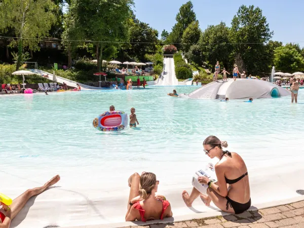 Parents et enfants profitent de la piscine du camping Roan Altomincio.