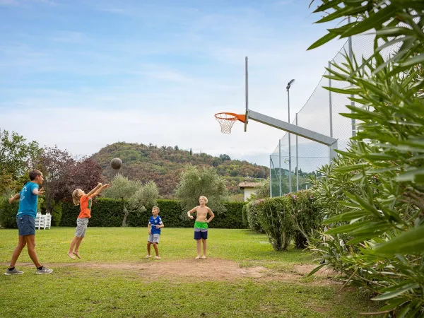 Des enfants jouent au basket au camping La Rocca Manerba.