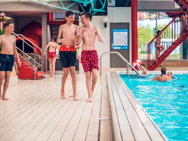 Jeunes jouant dans la piscine couverte du camping Roan Ackersate.