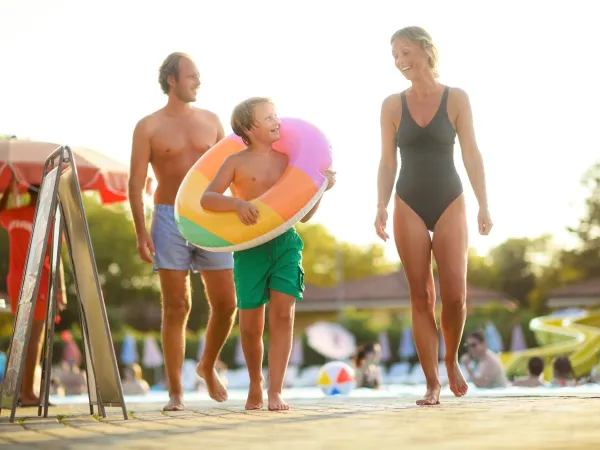 Père, mère et enfant au bord de la piscine du camping de Roan.
