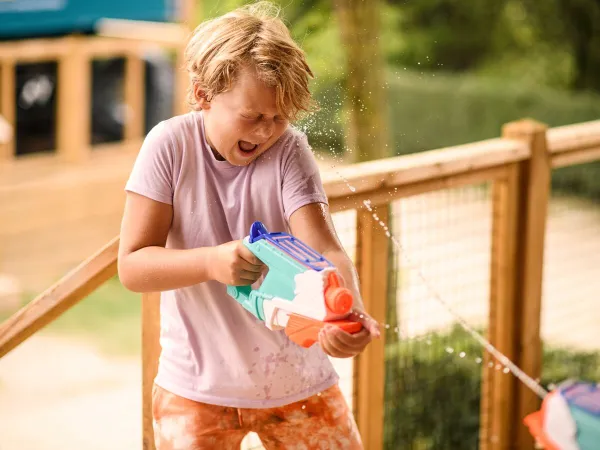 Enfant jouant avec un outil aquatique au camping Roan Le Domaine de Beaulieu.