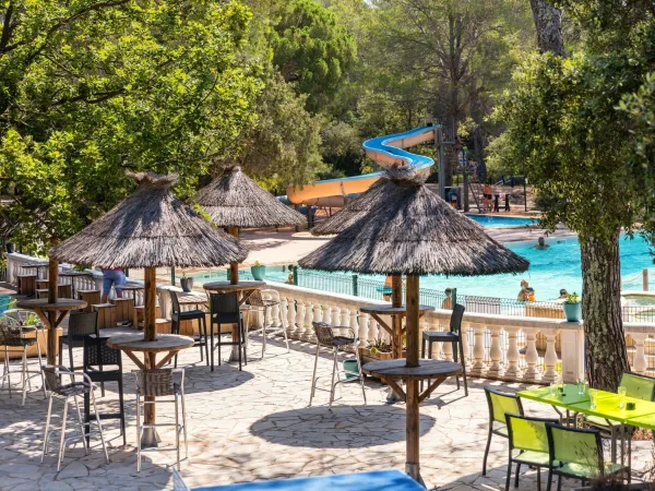 Terrasse au bord de la piscine du camping Roan La Pierre Verte.