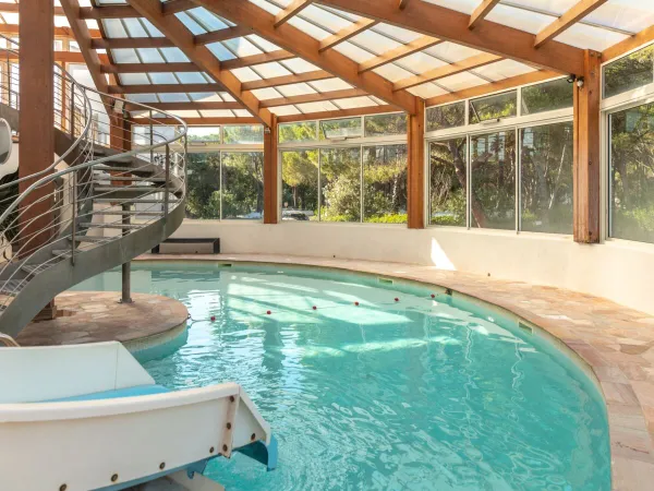 Piscine couverte avec toboggan aquatique au camping Roan La Baume.