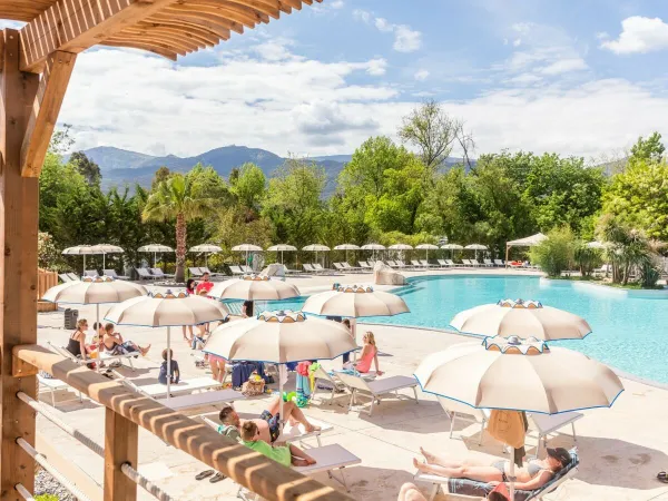 Chaises longues au bord de la piscine du camping Roan La Chapelle.