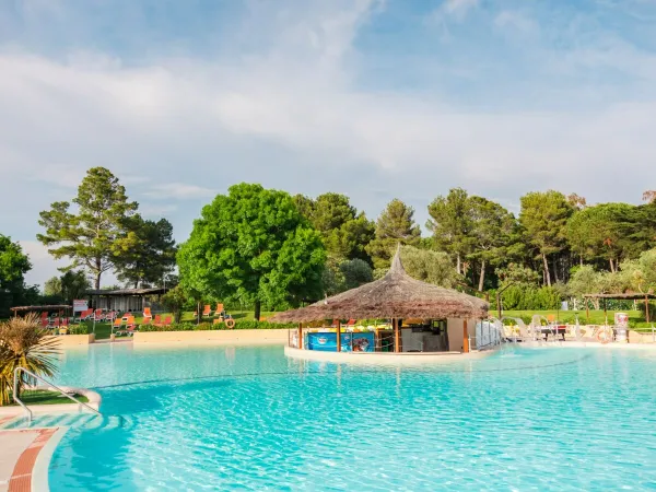 Piscine avec tente tiki au camping Roan Le Capanne.