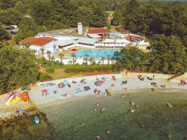 Vue d'ensemble de la plage de galets et de la piscine du camping Roan Bijela Uvala.