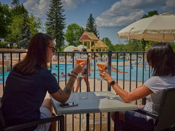 Terrasse au bord de la piscine du camping Roan Le Chêne Gris.