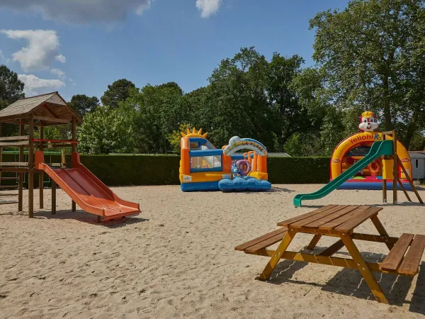 Aire de jeux avec châteaux gonflables au camping Roan La Clairière.