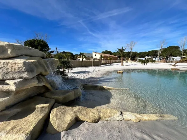 Cascade dans la piscine lagunaire en cours d'aménagement pour la saison 2024 au camping Roan Domaine de la Yole.