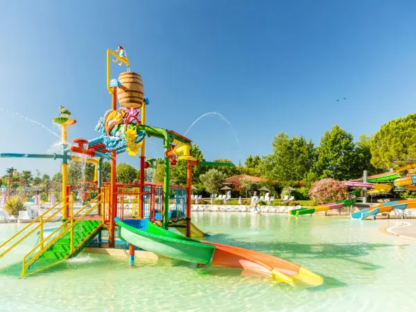 Aire de jeux dans la piscine lagunaire du camping Roan Bella Italia.