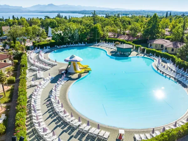 Piscine avec toboggans et chaises longues au camping Roan Bella Italia.