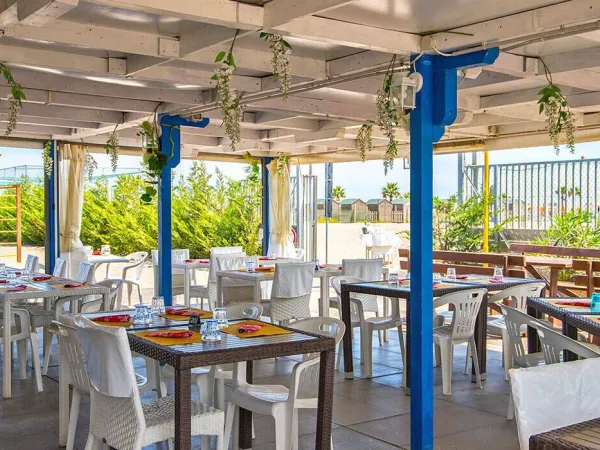 Terrasse avec parasols au camping Roan Sole Family Camping Village.