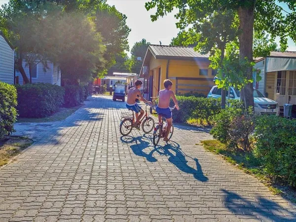 2 jeunes garçons traversent à vélo le camping Roan Sole Family Camping Village.