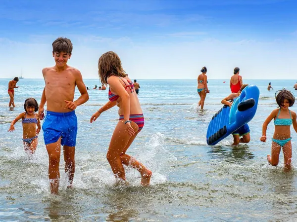 Les enfants jouent dans la mer au camping Roan Sole Family Camping Village.