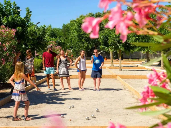 Une famille joue aux boules au camping Roan Le Castellas.