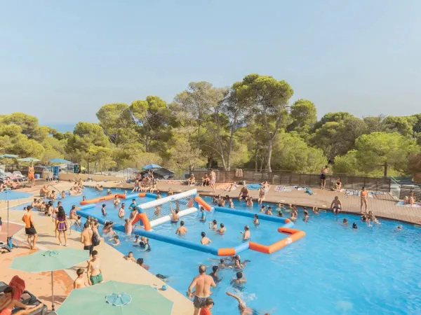 Des personnes jouent au volley-ball dans la piscine du camping Roan Internacional de Calonge.