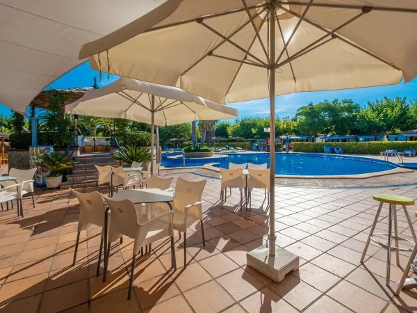 Terrasse au bord de la piscine du camping Roan La Masia.