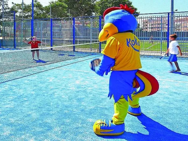 Mascotte sur le court de tennis du camping Roan La Masia.