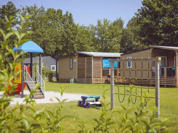 Terrain confortable avec des mobil-homes et une aire de jeux au Roan camping 't Veld.