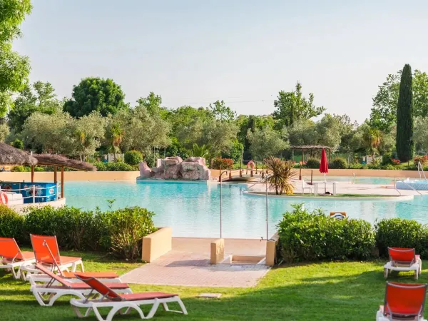Pré herbeux avec piscine et bar de piscine au camping Roan Le Capanne.