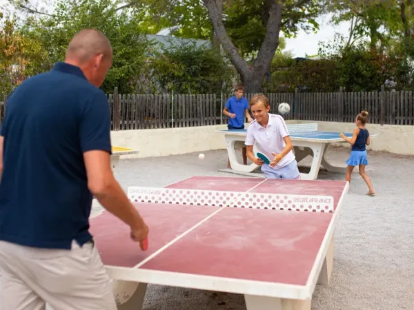 Père et fils jouent au tennis de table au camping Roan Domaine de la Noguière.